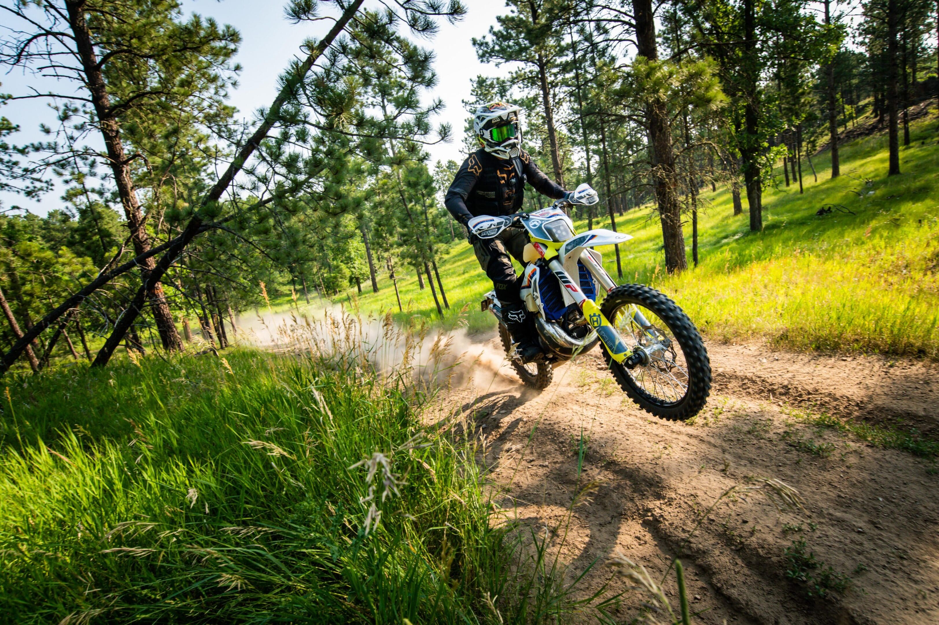 Dirt bike rider in forest trail.