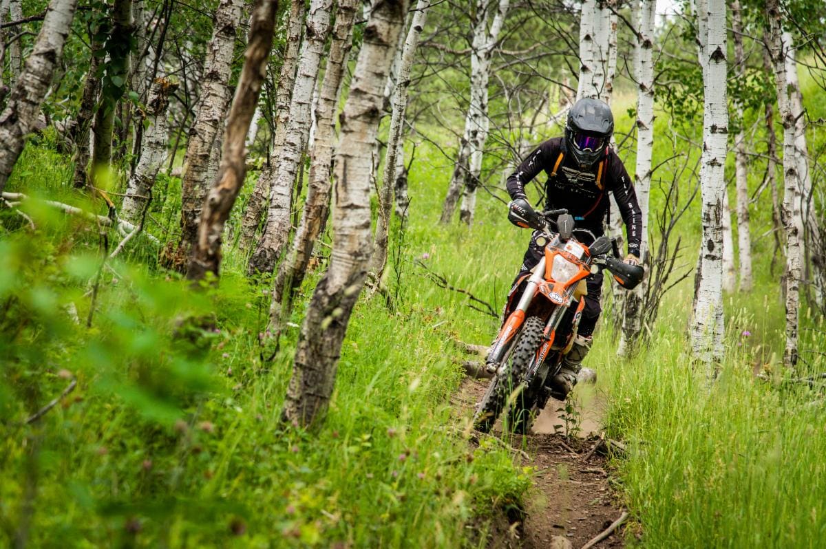 Motorcyclist riding dirt bike on trail.